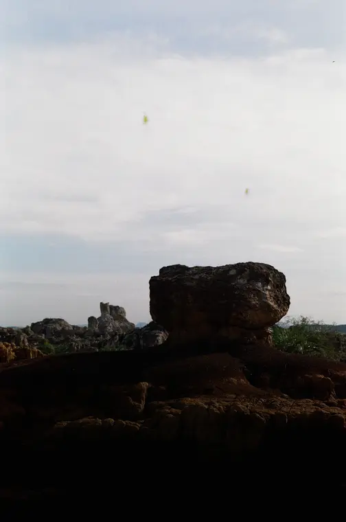 Balanced boulder silhouetted against an overexposed sky