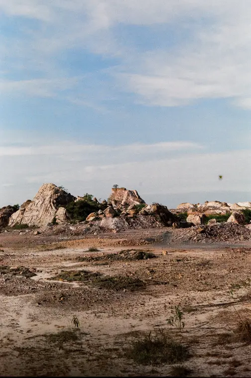Wide pale ground stretching to distant white rock spires
