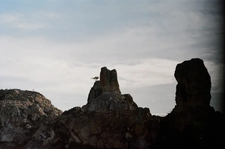 Silhouetted rock pillars against a cloudy sky