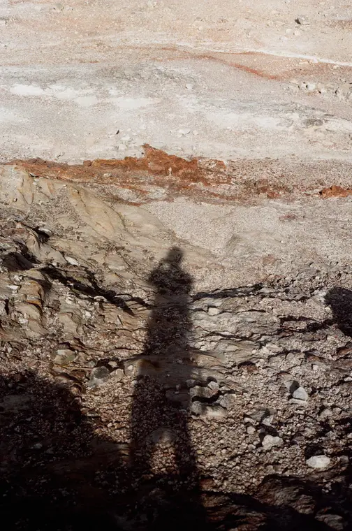 The photographer's shadow on a streaked rock wall