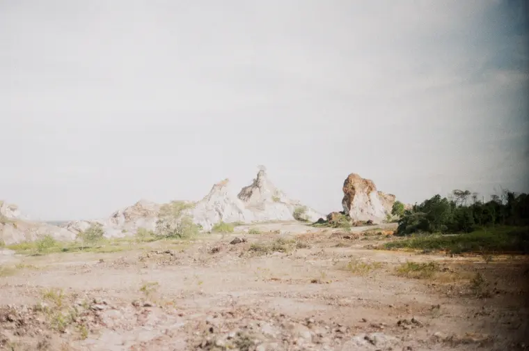 Faded wide view of white spires across flat ground